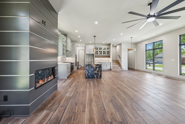 425 W Ft Worth St, Broken Arrow, OK 74012 - living area with baseboards, a glass covered fireplace, recessed lighting, a ceiling fan, and wood finished floors
