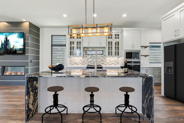 425 W Ft Worth St, Broken Arrow, OK 74012 - kitchen featuring a kitchen bar, decorative backsplash, stainless steel appliances, and dark wood-type flooring