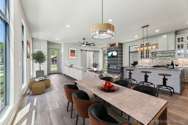 425 W Ft Worth St, Broken Arrow, OK 74012 - dining area featuring a glass covered fireplace, wood finished floors, recessed lighting, and ceiling fan