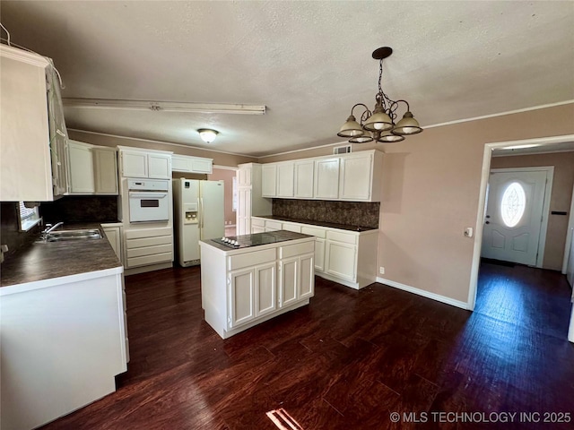 kitchen featuring a kitchen island, white cabinetry, decorative light fixtures, and white appliances