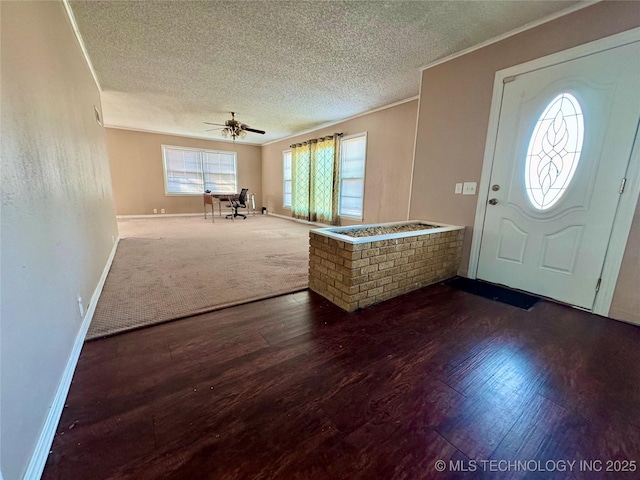 foyer featuring ceiling fan, crown molding, a textured ceiling, and hardwood / wood-style flooring