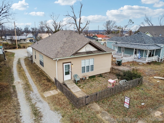 view of side of home featuring covered porch