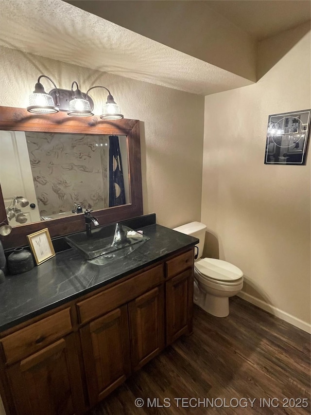 bathroom with wood-type flooring, vanity, and toilet