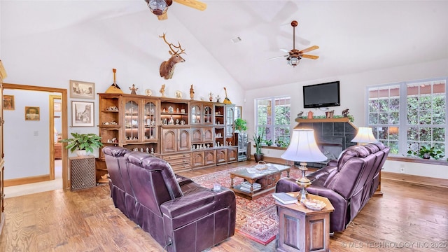 living room with high vaulted ceiling, light hardwood / wood-style flooring, and ceiling fan