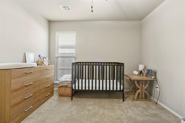 bedroom with light colored carpet and a crib