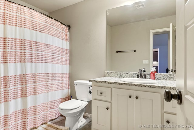 bathroom with curtained shower, vanity, and toilet