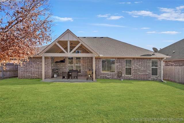 rear view of property with a lawn and a patio