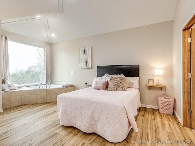 bedroom featuring light hardwood / wood-style floors and vaulted ceiling