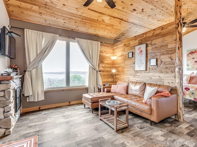 living room featuring ceiling fan, wood walls, wood-type flooring, and wooden ceiling