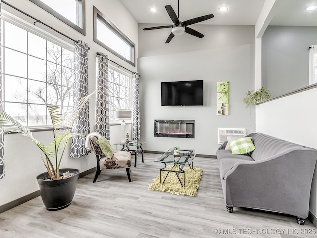 sunroom with a wall mounted AC and ceiling fan