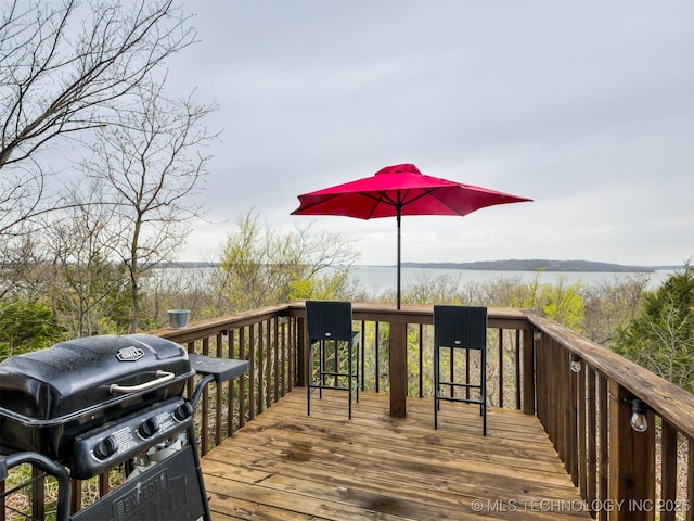 wooden terrace with a water view and grilling area