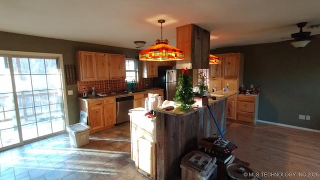 kitchen featuring appliances with stainless steel finishes, backsplash, hanging light fixtures, and ceiling fan