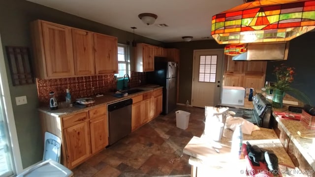 kitchen featuring pendant lighting, sink, decorative backsplash, appliances with stainless steel finishes, and light stone counters