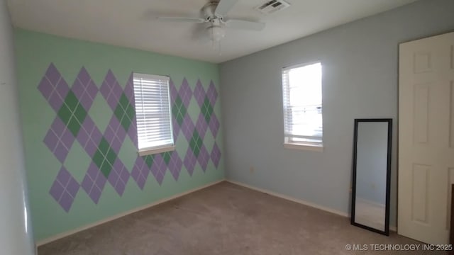 unfurnished room with ceiling fan and light carpet