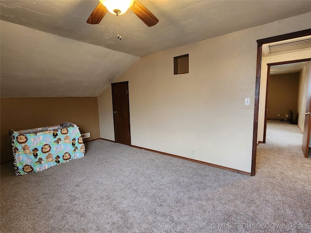 bonus room with ceiling fan, vaulted ceiling, light carpet, and a textured ceiling