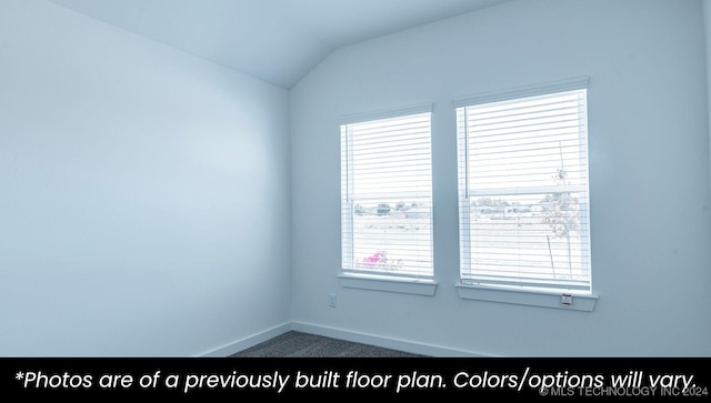 carpeted spare room featuring vaulted ceiling and a healthy amount of sunlight