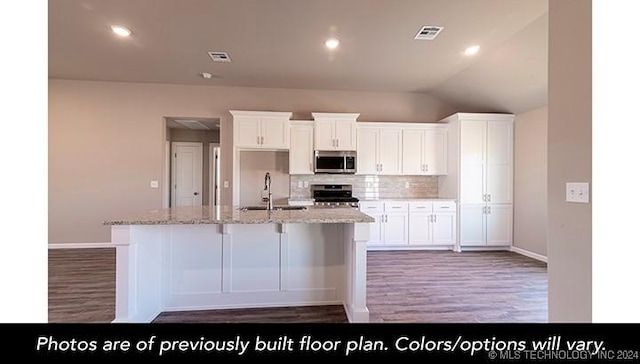 kitchen featuring white cabinetry, light stone counters, range, and an island with sink