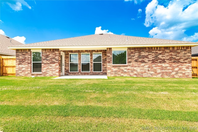 rear view of property with a lawn and a patio