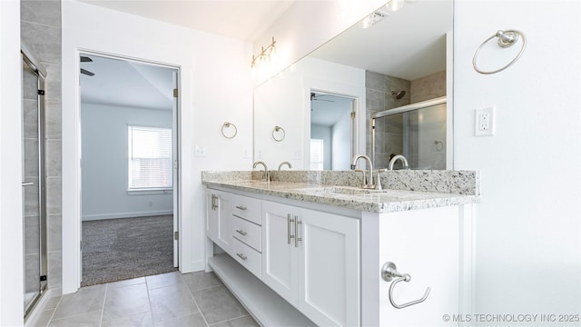 bathroom with tile patterned floors, ceiling fan, vanity, and an enclosed shower