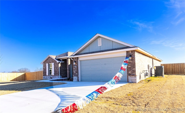 ranch-style home featuring central AC and a garage