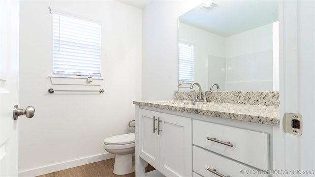 bathroom featuring wood-type flooring, vanity, and toilet