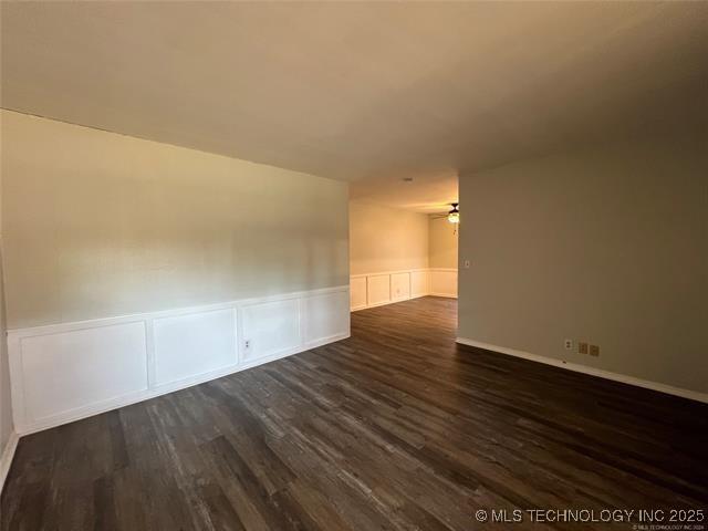 unfurnished room featuring ceiling fan and dark hardwood / wood-style flooring