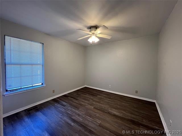 empty room with ceiling fan and dark hardwood / wood-style floors