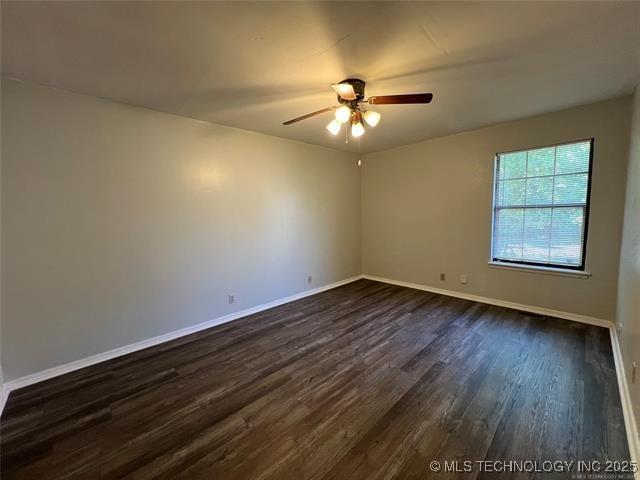 unfurnished room with ceiling fan and dark hardwood / wood-style floors