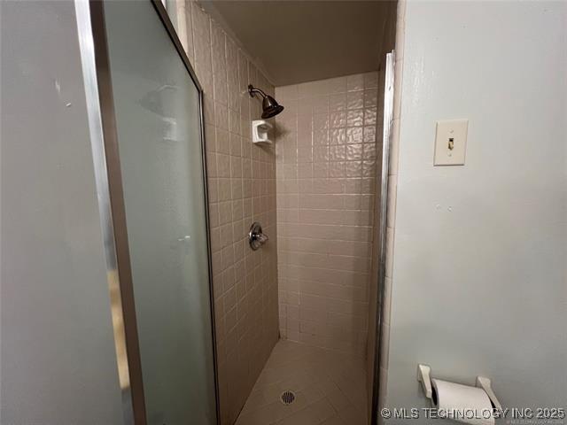 bathroom featuring a shower with door