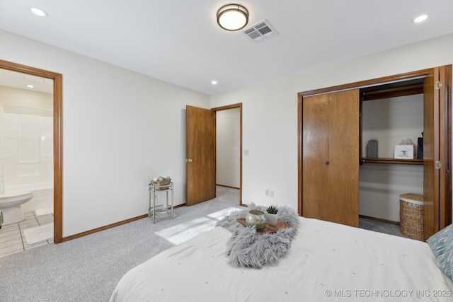 carpeted bedroom featuring connected bathroom and a closet