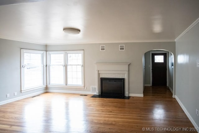 unfurnished living room with crown molding and hardwood / wood-style flooring