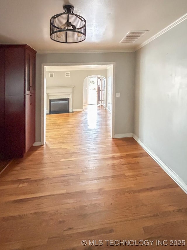 hall with crown molding and light hardwood / wood-style flooring