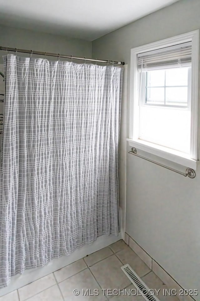 bathroom with tile patterned floors and shower / bathtub combination with curtain