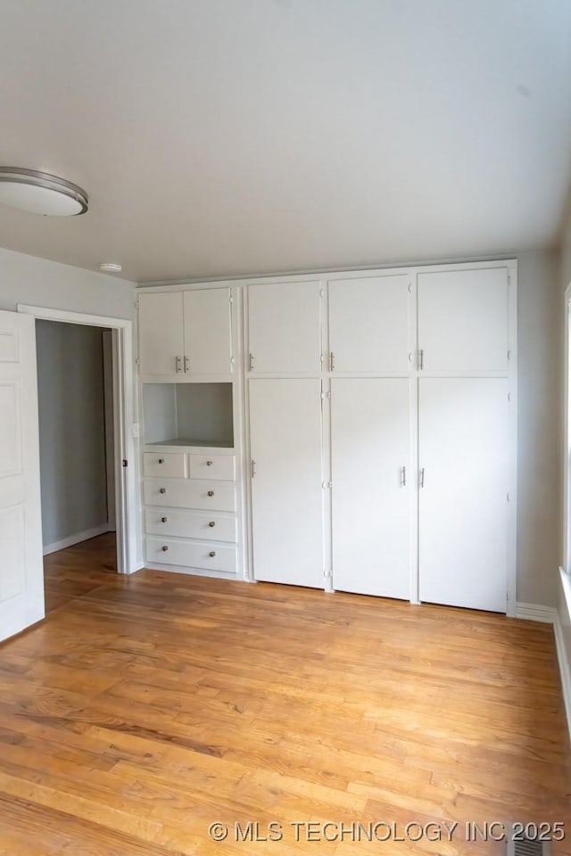 unfurnished bedroom featuring a closet and light hardwood / wood-style floors