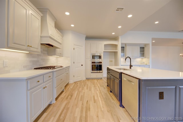 kitchen featuring white cabinets, a spacious island, sink, and appliances with stainless steel finishes