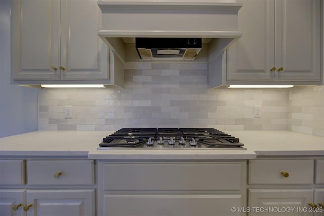 kitchen featuring stainless steel gas cooktop, white cabinetry, extractor fan, and tasteful backsplash