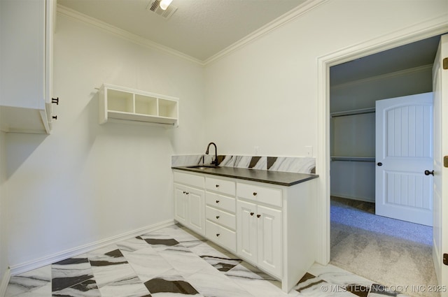 laundry area featuring sink, a textured ceiling, and ornamental molding