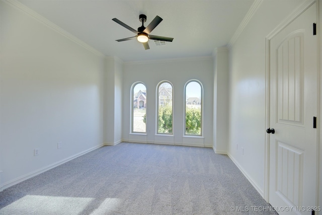 carpeted spare room with ceiling fan and ornamental molding