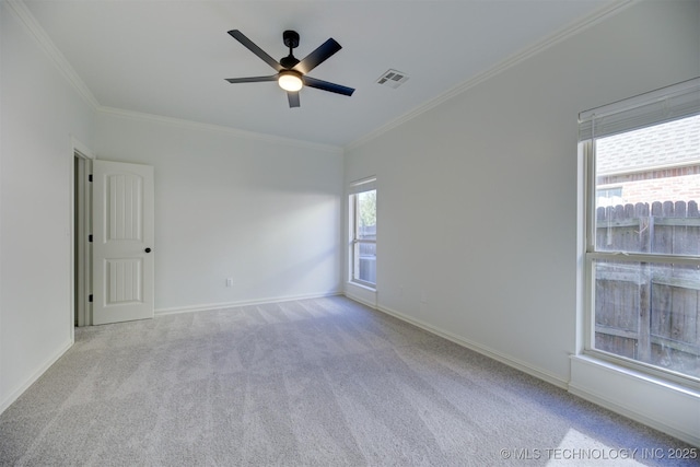 carpeted spare room featuring ceiling fan and crown molding