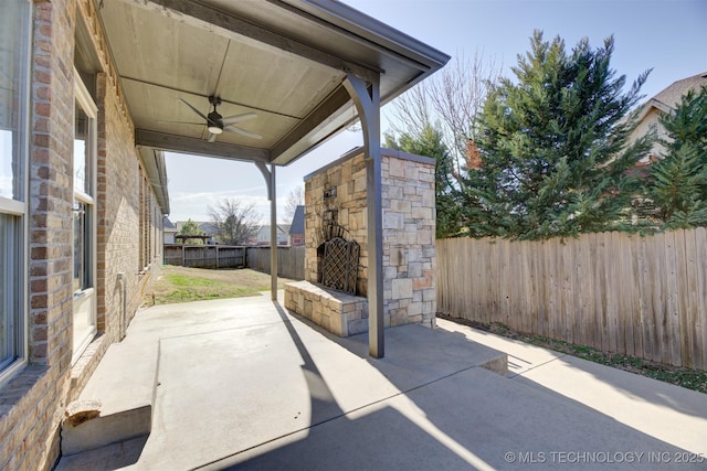 view of patio featuring ceiling fan and an outdoor stone fireplace