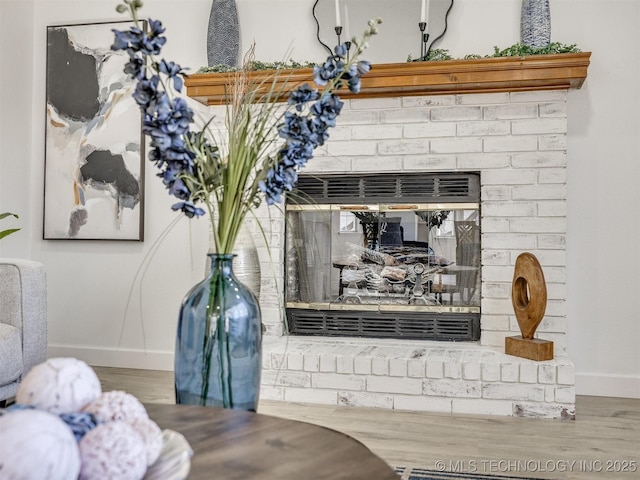 room details with hardwood / wood-style floors and a brick fireplace