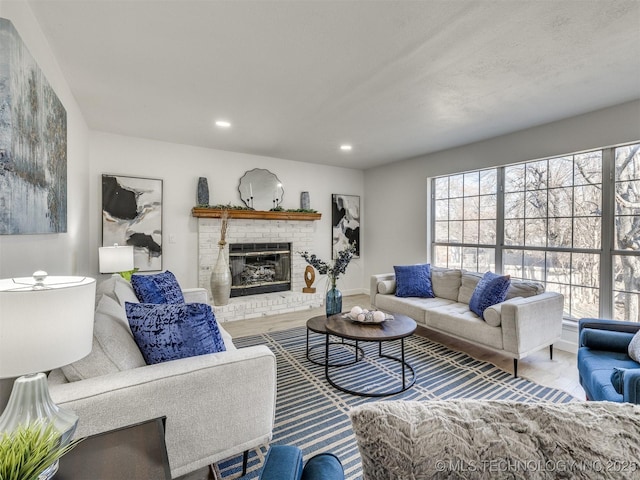 living room featuring wood-type flooring and a brick fireplace