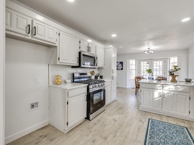 kitchen with french doors, stainless steel appliances, tasteful backsplash, light hardwood / wood-style flooring, and white cabinets