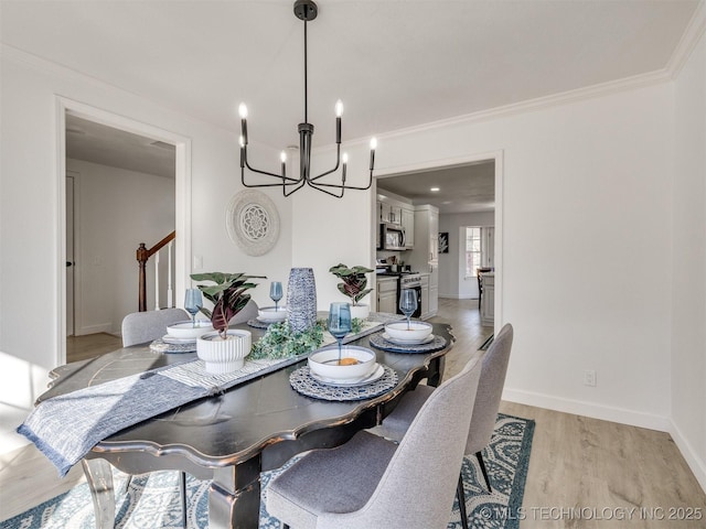 dining room with a chandelier, light hardwood / wood-style flooring, and crown molding