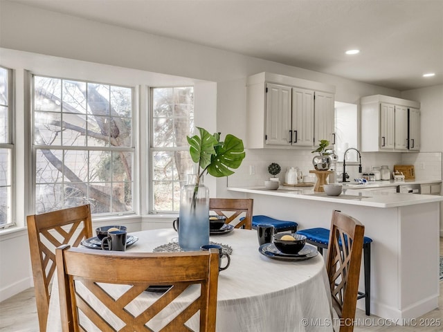 kitchen featuring backsplash, a wealth of natural light, sink, and white cabinets