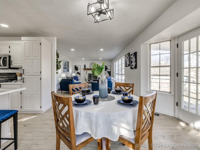 dining area featuring light hardwood / wood-style floors and a chandelier