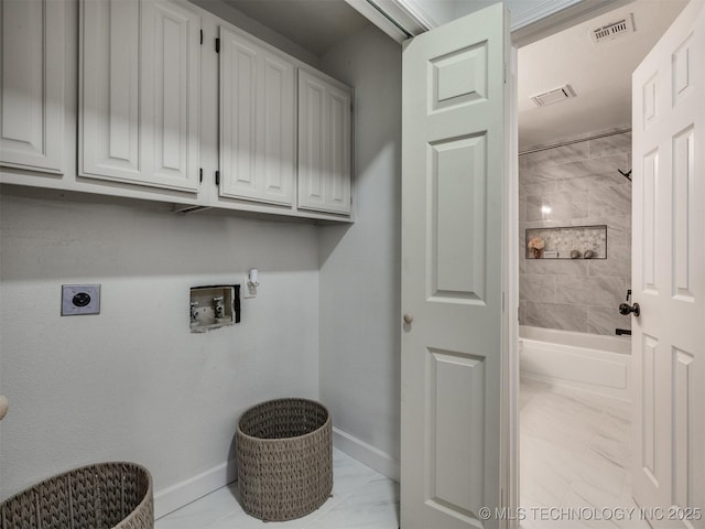 clothes washing area featuring washer hookup, electric dryer hookup, light tile patterned flooring, and cabinets