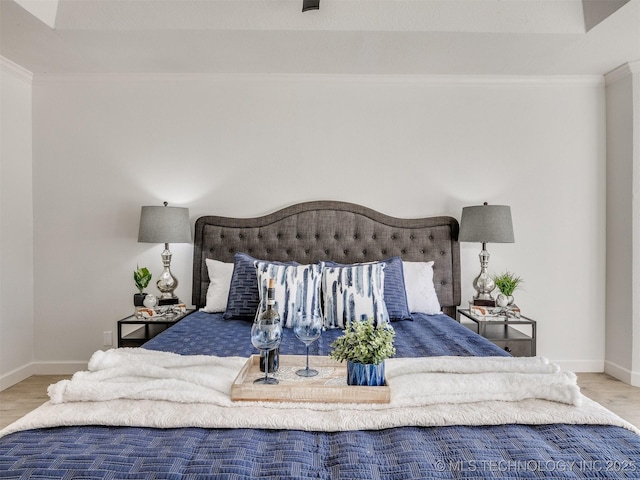 bedroom with light hardwood / wood-style floors and ornamental molding