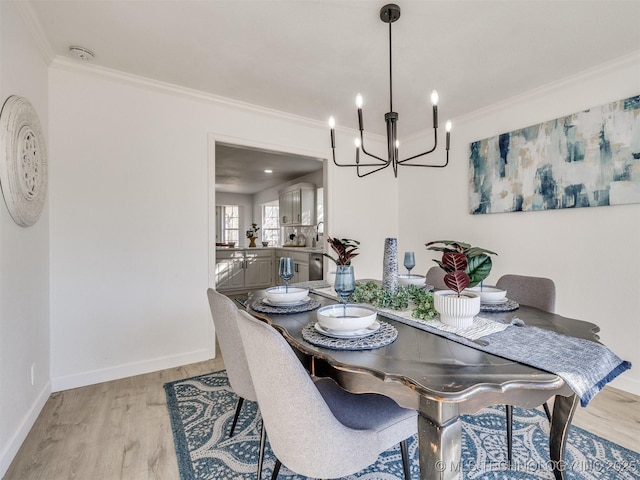 dining space featuring ornamental molding, light hardwood / wood-style flooring, and an inviting chandelier