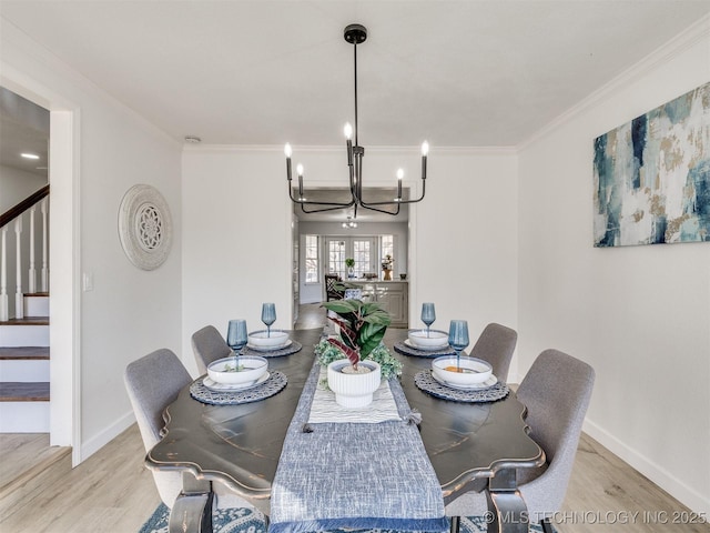 dining area featuring ornamental molding, light hardwood / wood-style floors, and an inviting chandelier